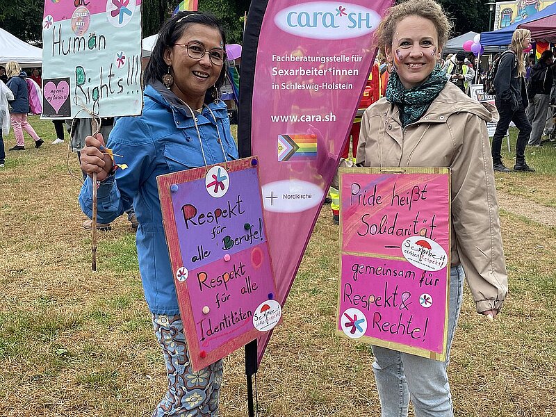 Zwei Frauen an einer Beachflag mit Demo-Transparenten
