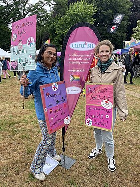 Zwei Frauen an einer Beachflag mit Demo-Transparenten