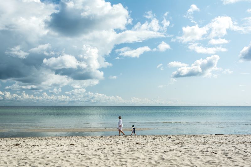 Strand und meer, am Ufer laufen eine Frau und ein Kind